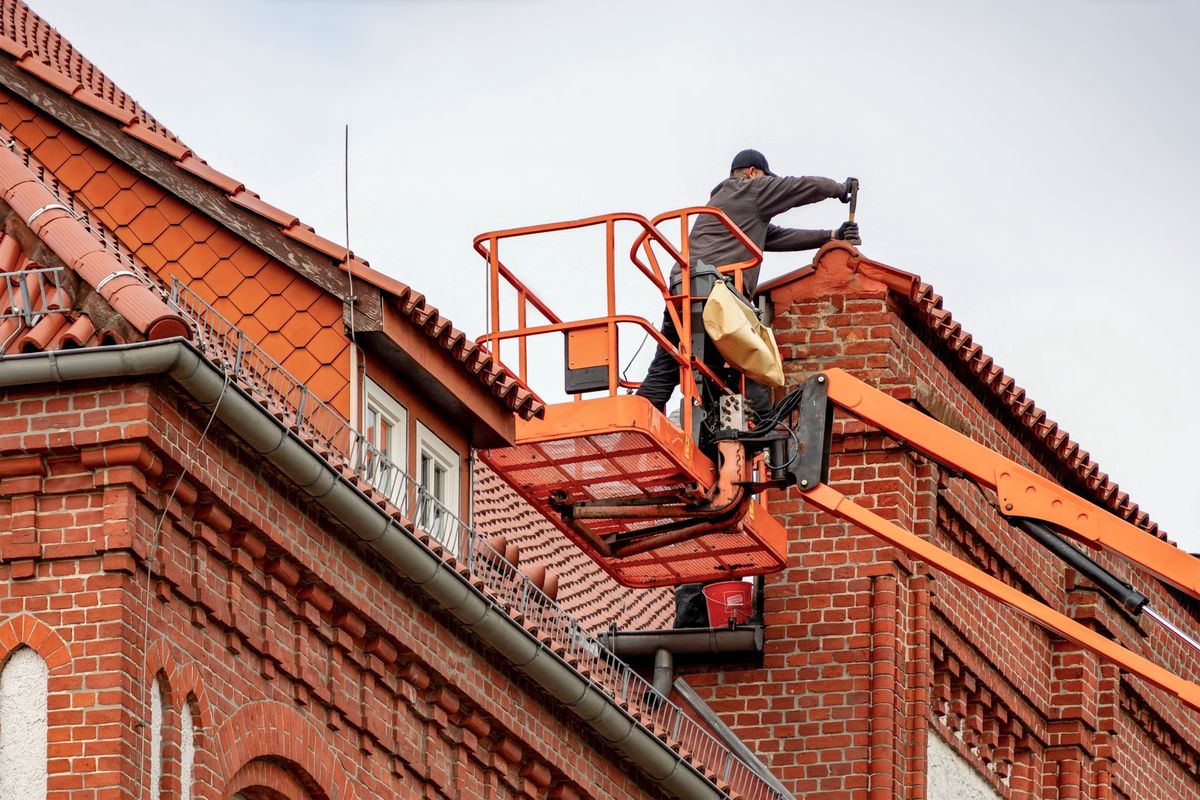 Dakspecialist in een hoogwerker aan het werk